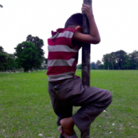 A boy stand on a pole